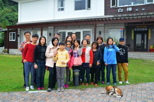 a group of people posing for a picture with a dog at Feng Xian Bai Hua B&B in Guanshan