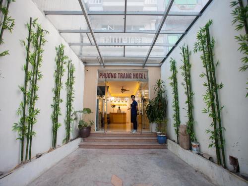 a man standing in the doorway of a store at Phuong Trang Hotel in Hanoi