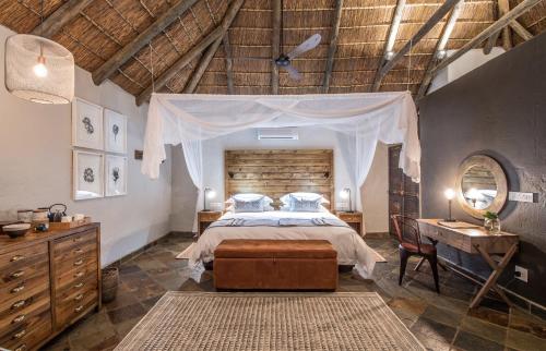 a bedroom with a bed and a dresser and a table at Lalibela Game Reserve - Inzolo Lodge in Sidbury