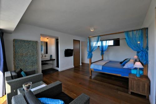a bedroom with a blue bed with blue curtains at Villa La Laguna in Lajares