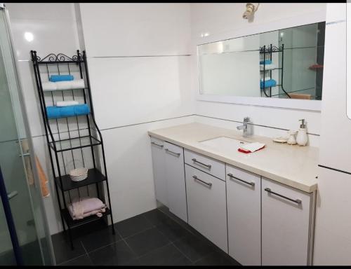 een badkamer met een wastafel en een spiegel bij mi casa es su casa in Ashkelon