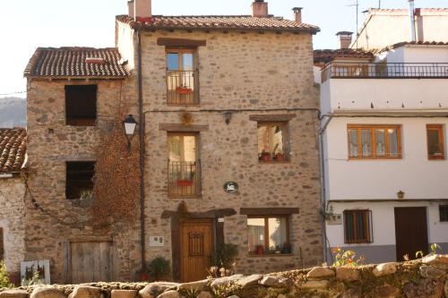 un antiguo edificio de piedra con ventanas y una puerta en Casa Rural Uyarra, en Ojacastro