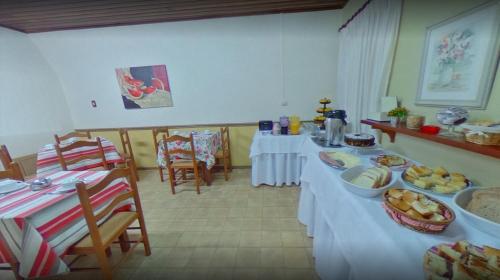 Hotel Primavera في بينتو جونكالفيس: غرفة بها طاولتين عليها طعام