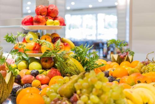 Una exhibición de frutas y verduras en una mesa. en Spring Hotel Vulcano, en Playa de las Américas