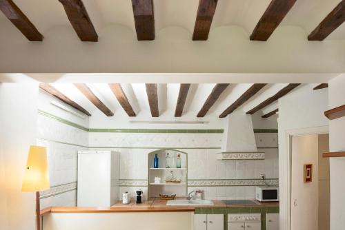 cocina con paredes blancas y techos de madera en Apartamento De La Fuente, con terraza y parking, en Cuenca