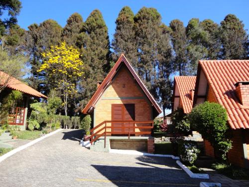 una casa con techo rojo en Hotel Cabana Jardim de Flores, en Gramado