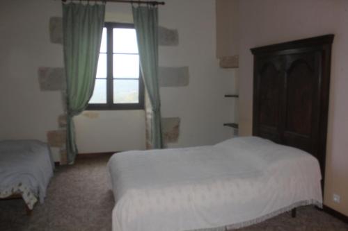 a bedroom with a bed and a window at Chateau de Presque in Saint-Médard-de-Presque