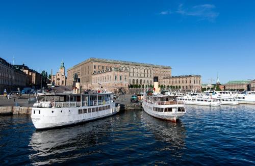 two boats are docked in the water in a harbor at Lady Hamilton Apartments in Stockholm
