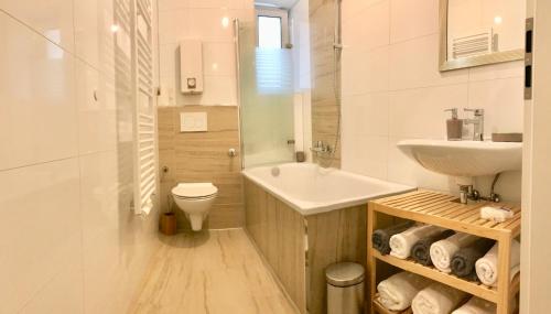a white bathroom with a sink and a toilet at FeWo Apartments House in Essen