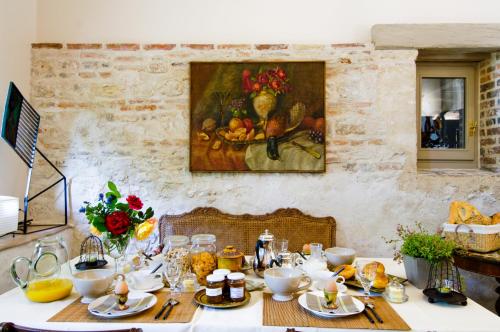 une table avec une peinture d'un vase de fruits dans l'établissement La Ferme de Marie Eugénie, à Bruailles