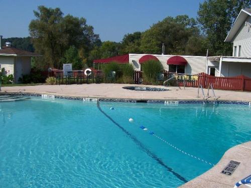 une grande piscine bleue en face d'une maison dans l'établissement Byrncliff Maple Lodge, à Varysburg