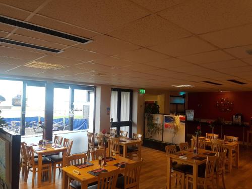 a restaurant with wooden tables and chairs in a room at The Shipwreck Loft in Shotley Gate