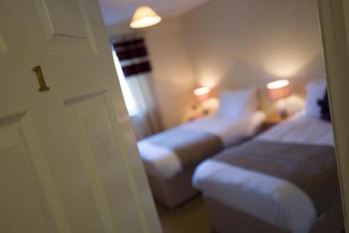 a hotel room with two beds and a window at The Roast Ox Inn in Builth Wells