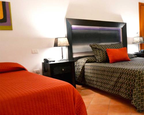 a hotel room with two beds and a headboard at Relais Villa Buonanno in Cercola