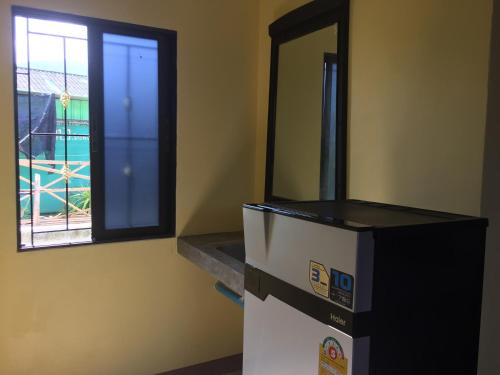 a refrigerator in a room with a window at Chill land house in Bang Tao Beach