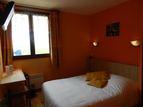 a bedroom with a white bed and a window at Logis Auberge De La Plaine in La Rothière