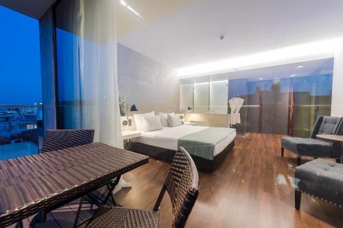 a hotel room with a bed and a table and chairs at Lux Lisboa Park in Lisbon