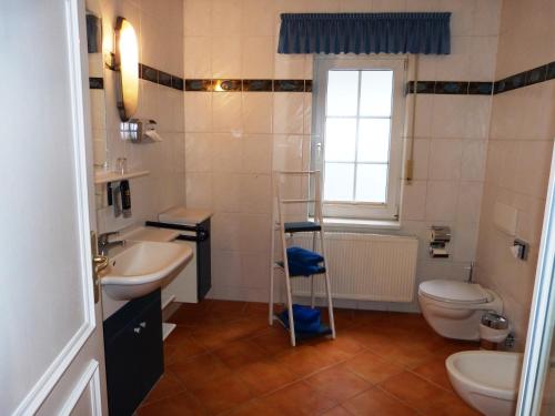 a bathroom with a toilet a sink and a bathtub at Vogel Hotel Appartement & Spa in Warnemünde