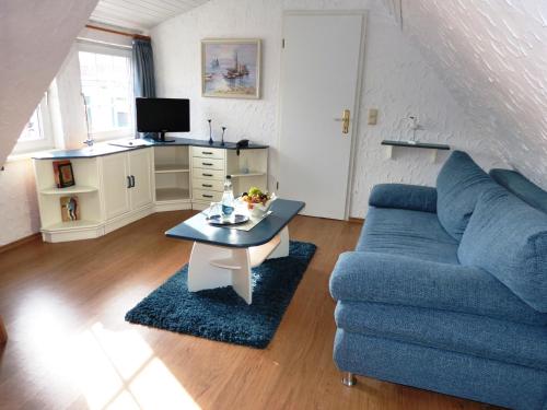 a living room with a blue couch and a table at Vogel Hotel & Appartements in Warnemünde