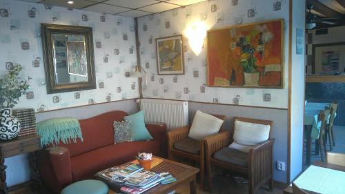 a waiting room with a couch and two chairs at Hotel La Croix des Bois in Lalizolle