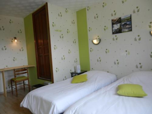 two beds in a room with green walls at Logis Auberge De La Plaine in La Rothière