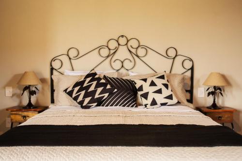 a bedroom with a large bed with black and white pillows at Pousada Estância das Montanhas in Águas de Lindóia