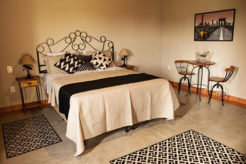 a bedroom with a bed and a table and chairs at Pousada Estância das Montanhas in Águas de Lindóia