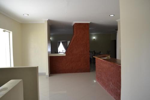 una sala de estar con una pared roja y un mostrador en Zakinn Hotel Gangilonga, en Iringa