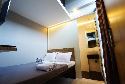 a small room with a bed with a sloped ceiling at The Lively Hotel Kualanamu in Medan