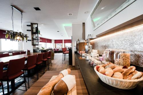 a restaurant with a counter with bread and a bar at Aparthotel Dorfplatzl Garni in Tux