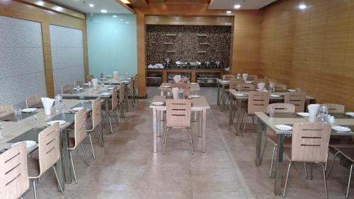 a dining room with tables and chairs and a fireplace at Rosewood International Hotel in Bengaluru
