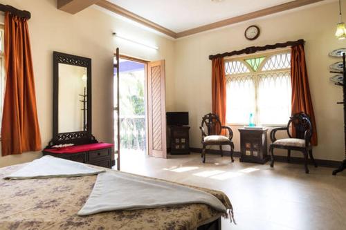 a bedroom with a bed and a mirror and a desk at The Pereira's Goan Homestay Villa in Vasco Da Gama