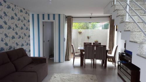 a living room with a couch and a table with chairs at Residencial San Sebastian in Garopaba