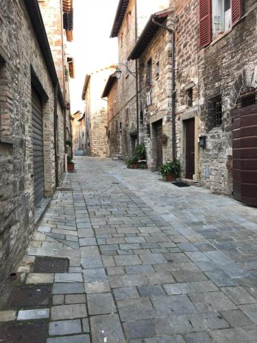 an empty street in an alley with stone buildings at Mamihouse in Gubbio