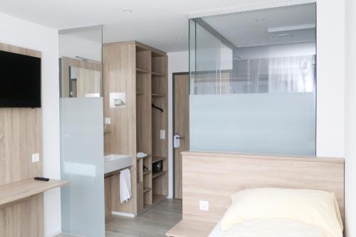 a bedroom with a bed and a mirror and a sink at Hotel Traube Garni in Küttigen