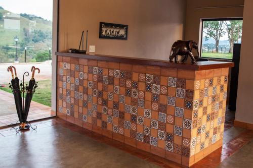 a statue of a dog sitting on top of a tile wall at Pousada Estância das Montanhas in Águas de Lindóia