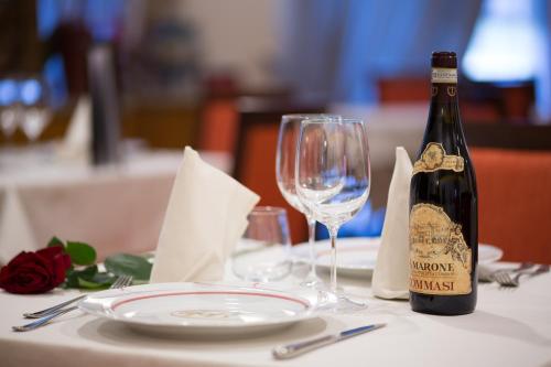 a bottle of wine sitting on a table with a glass at Hotel Brandoli in Verona