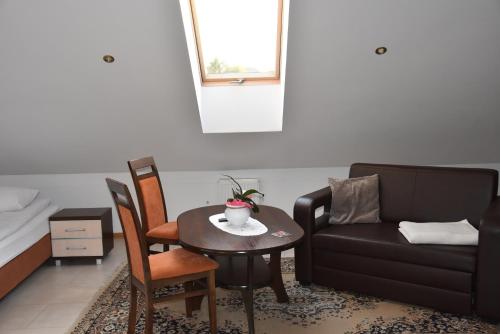 a living room with a table and a couch at Gościniec Klejnot in Borowo