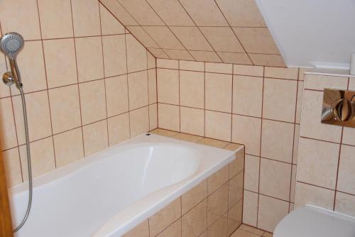 a small bathroom with a tub and a shower at Gościniec Klejnot in Borowo