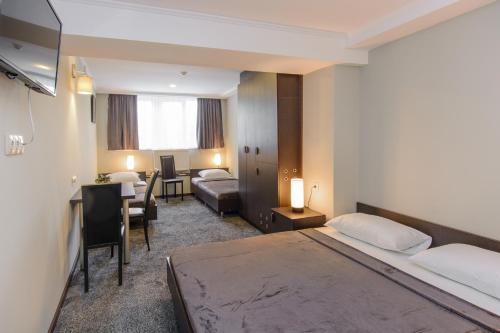 a hotel room with a bed and a desk at Hotel Reverence in Tbilisi City