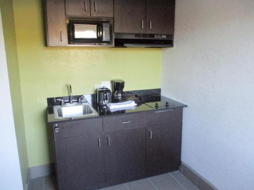 a kitchen with a sink and a microwave at Studio 6-Monroe, LA - Hwy 165 in Monroe
