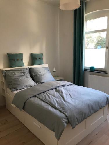 um quarto com uma cama com lençóis azuis e uma janela em 5min City Zentral - Wohnen am Werdersee Neustadt em Bremen