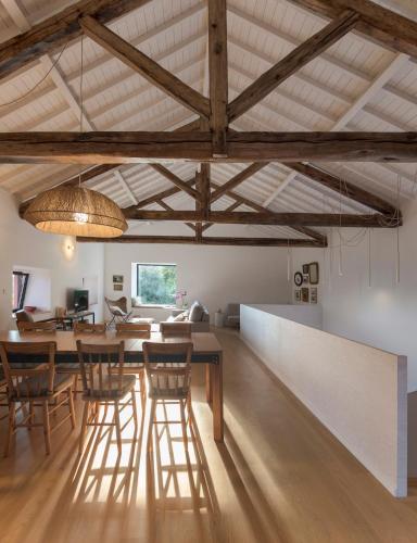 a dining room and living room with wooden beams at Pelago Houses in Ponta Delgada