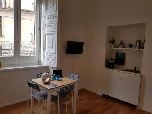 Una cocina con una mesa y sillas en una habitación. en Via Roma Apartment Deluxe, en Salerno