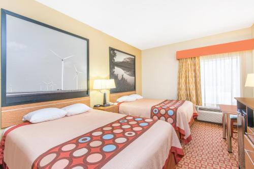 a hotel room with two beds and a television at Super 8 by Wyndham Wichita South in Wichita