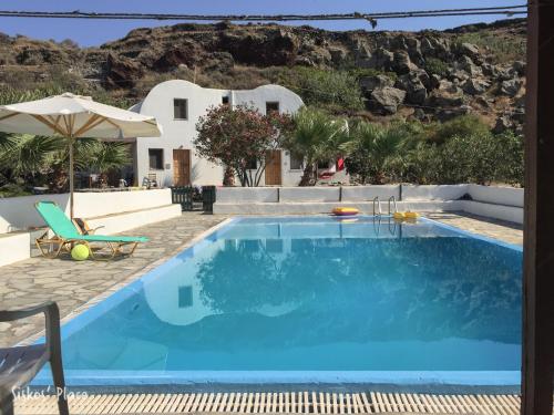 a swimming pool with a villa in the background at Siskosplace in Oia