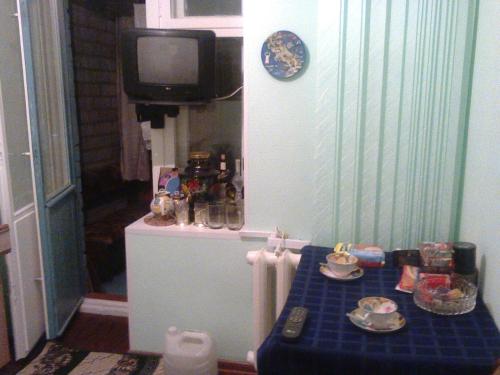 キロフスクにあるLeningradskaya 30の青いテーブル、壁掛けテレビが備わる客室です。