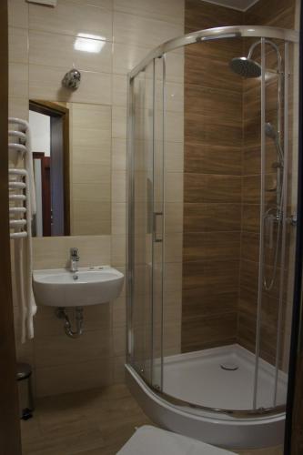 un baño con ducha y lavabo en Pensjonat Perła Pienin, en Grywałd
