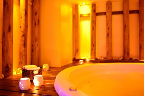 a bathroom with a tub and candles on a wooden floor at Pestana Buenos Aires in Buenos Aires