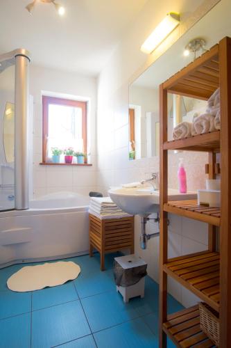 a bathroom with a sink and a tub and a toilet at 4U Apartments - Zakopane in Zakopane
